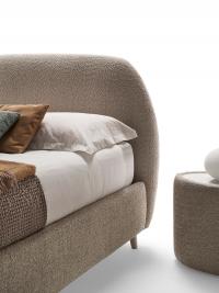 Detail of the rounded headboard of Antilla bed, removable cover in bouclé fabric Venice