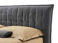 Detail of the padded headboard with a quilted hood-shaped cover