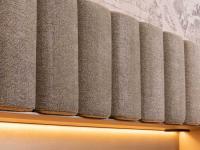 The upholstered slats composing the wall panelling can be covered in a wide range of materials (fabric, faux-leather, leather)