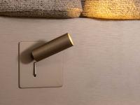 Lacquered metal spotlights, available as optional, on the side of the headboard