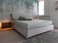 Storage double bed in aqua green velvet with suspended wooden bedside tables with LED lighting.