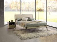 Nobel upholstered bed with leather upholstery that leaves the high metal feet visible