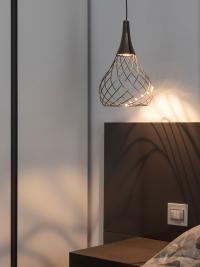 Detail of the soft light from the Mongolfier lamp suspended above the bedside tables