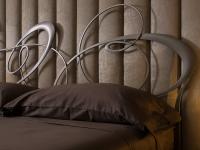 Lounge fabric boiserie combined with a bed (Ghirigori) with an impressive metal headboard