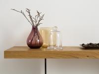 Detail of the 5 cm thick top in honey knotty oak and bronze-finished glass legs