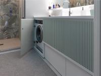 Bespoke bathroom cabinet with washing machine base with door, storage baskets and laundry baskets.