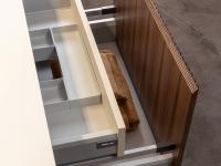 View of the interior surface of the fronts veneered in Canaletto walnut. The bottom of the internal drawer of the basin base unit is curved for the passage of the drain pipe
