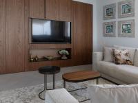 The bespoke wooden wall unit has a TV compartment and a horizontal open niche.