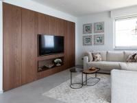 Furniture design for the living room's relaxation area: a bespoke wall unit, a sofa, coffee tables, and decorative objects.