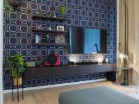 Wall unit with suspended base, shelves, space for wall-mounted TV. Blue and gold wallpaper.