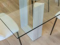Detail of extra-clear glass table top and travertine marble stone base