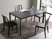 Main extending table with anthracite-coloured painted metal triangular legs, coordinated with the glass top and chairs