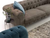 Detail of the leather sofa matched with velvet armchair and cushions