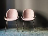 Athena upholstered chair with thin legs and a padded seat with a comfortable, welcoming form