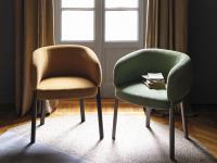 Hamide armchair with wooden legs and curved back upholstered in fabric