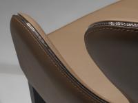 Close-up of the curved armrest and backrest with decorative chromed zip