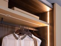 Detail of the clothes hanger rods in matte brown lacquered metal combined with dark elm melamine interiors