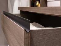 Close up of the drawer with groove handle in matt lacquered metal (titanium)