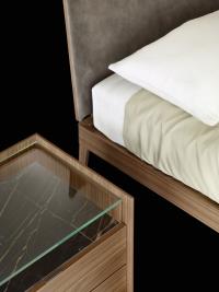 Detal of the bedside table with clear glass upper top and ceramic lower one