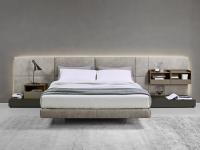 California upholstered bed with wall panelling matched with bedside tables