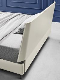 Back view of the lacquered headboard on an upholstered bed-frame covered in faux-leather
