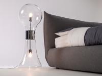 Edi lamp placed next to an upholstered bed