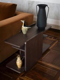 The Holiday side table next to a sofa, made from dark Earth Oak wood
