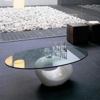 Dubai elliptical coffee table with sculptural white lacquered base and transparent glass top, designed for sofa front.