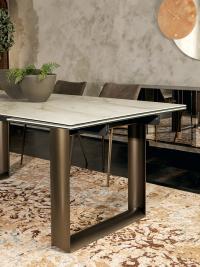 Details on Cube table with stoneware top and veneer structure in curved and painted metal.