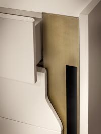 Detail des Metallaufsatzes und der seitlichen Leiste der Schubladenfronten. Die Formgebung ermöglicht das Öffnen der Schubladen.
