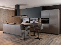 Küche mit Kochinsel und integrierter Arbeitsplatte, die sich durch die Zweifarbigkeit der Unter- und Oberschränke auszeichnet
