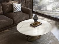 Runder Couchtisch mit Basis im gedrechselten Design Vortex vor dem Sofa positioniert mit Tischplatte in Marmor Carrara und Basisstruktur in Metall gestrichen Bronzo.