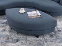 Particolare del pouf ovale che si inserisce nella curvatura del divano per formare un'isola relax