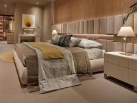 Elegantes Lounge-Sommier-Bett mit niedrigem Kopfteil, ausgestattet mit offenem Fach in Metalloptik und passenden Strahlern