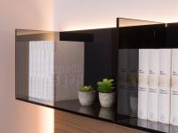 Bücherregal aus Rauchglas, ein kontrastreiches Element zur Wärme des Holzes in dieser Version der Replay 04 Wohnwand