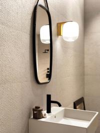 Gong-Wandleuchte als Lichtpunkt neben dem Badezimmerspiegel