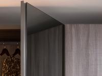 Detail einer Spiegeltür mit geschwungener Griffmulde in voller Höhe aus bleimatt lackiertem Metall