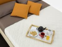 Bettdecke mit Rauten gesteppt mit einem Polsterbett abgebildet