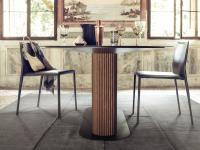 Tisch mit zentralem Untergestell aus Savannah Lamellenholz kombiniert mit Corinne Stühlen