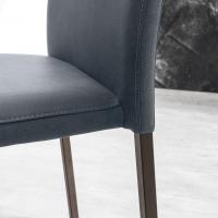 Dettaglio dello schienale della sedia Letty, rivestita in ecopelle vintage antracite e struttura verniciata Corten