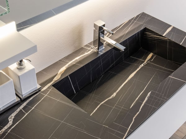 Dettaglio del top bagno in laminato effetto marmo scuro Vittoria