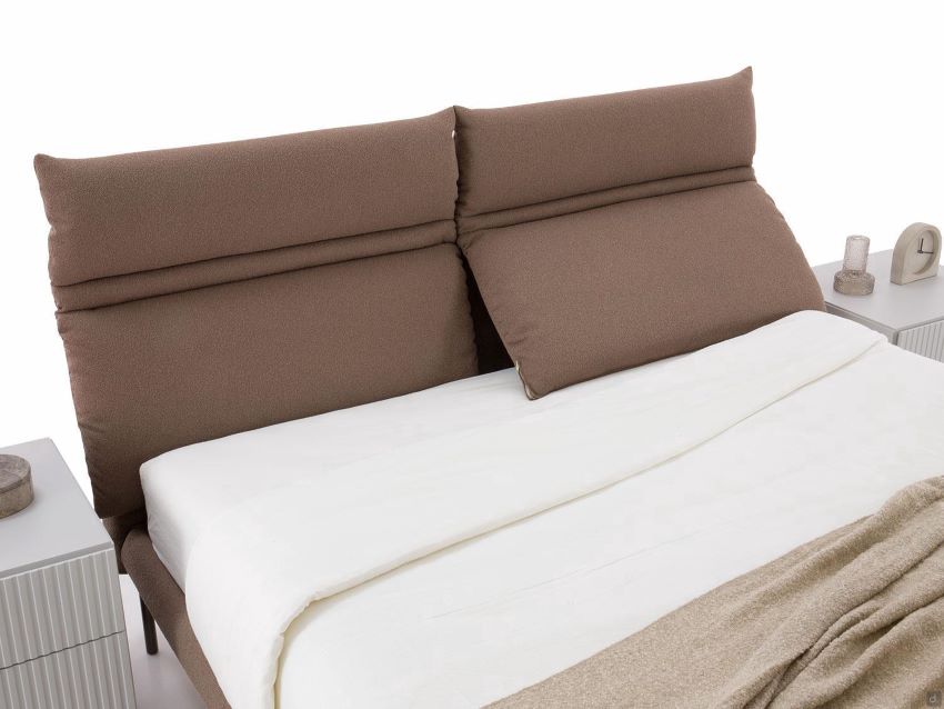 Dettaglio di un letto con cuscini di testiera inclinabili