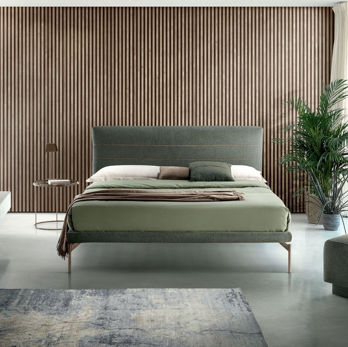 Camera da letto elegante con boiserie in legno e letto con testiera imbottita color verde oliva