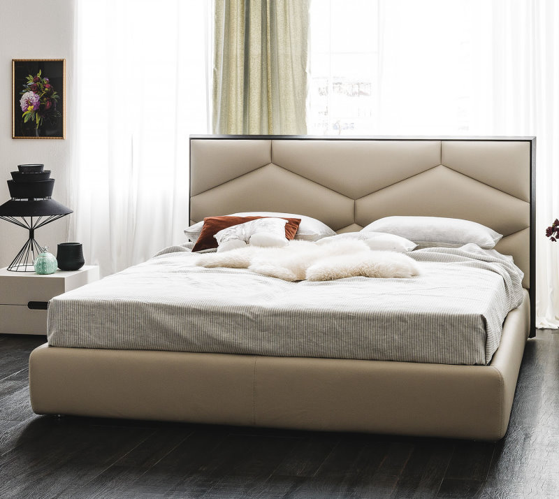 Il letto Edward è caratterizzato da testiera alta imbottita con decorazione geometrica e bordo in legno noce o rovere