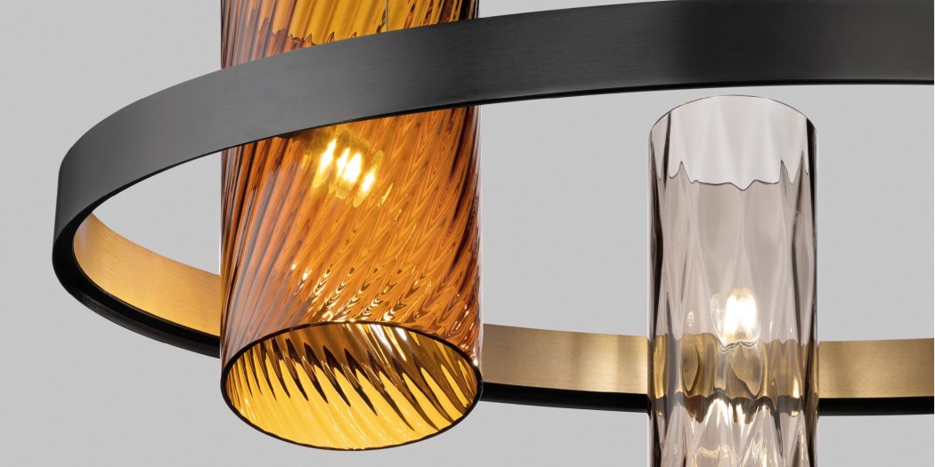 Dettaglio di un lampadario con diffusore cilindrico in vetro ambrato a coste diagonali