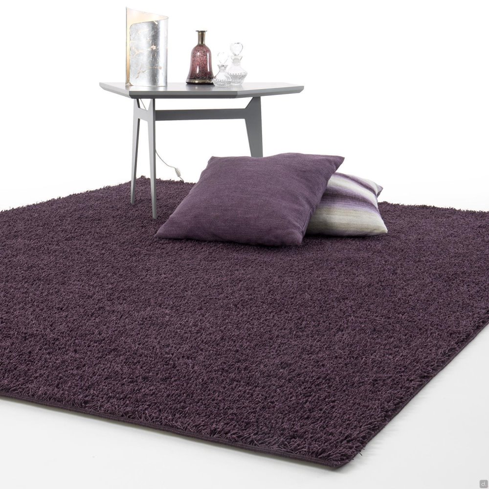 Tappeto a pelo lunga viola tinta unita con cuscini e tavolino