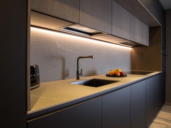 Cucina tutta nera con piano grigio e retroilluminazione LED