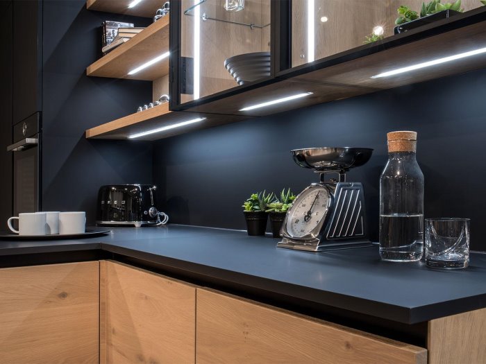 Cucina angolare in nero e legno con LED sottopensili