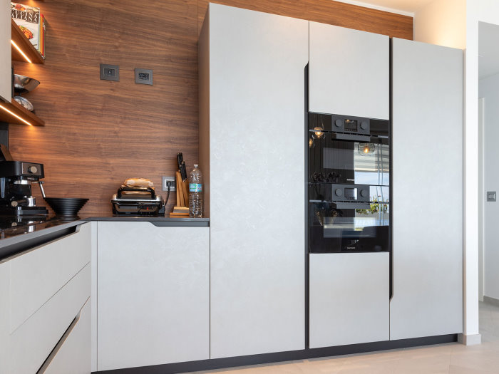 Dettaglio della cucina con frigorifero e colonna forno / microonde