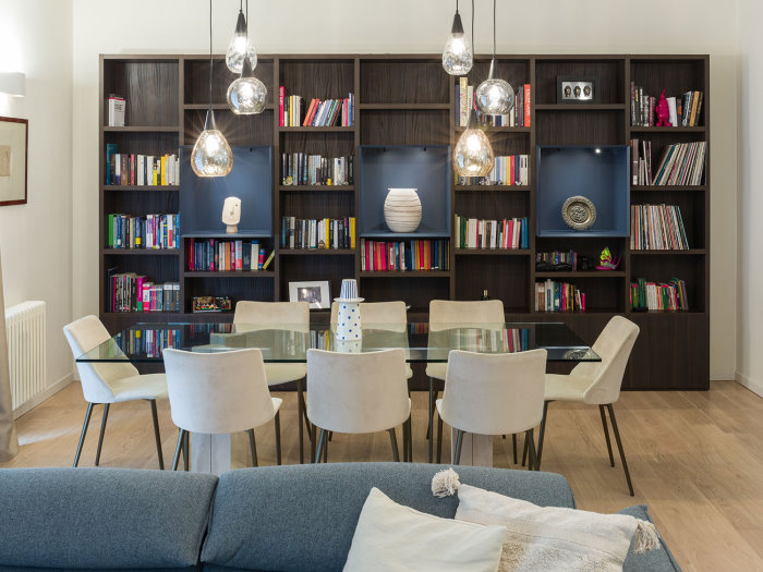 Vista d'insieme della zona pranzo con tavolo e libreria da parete